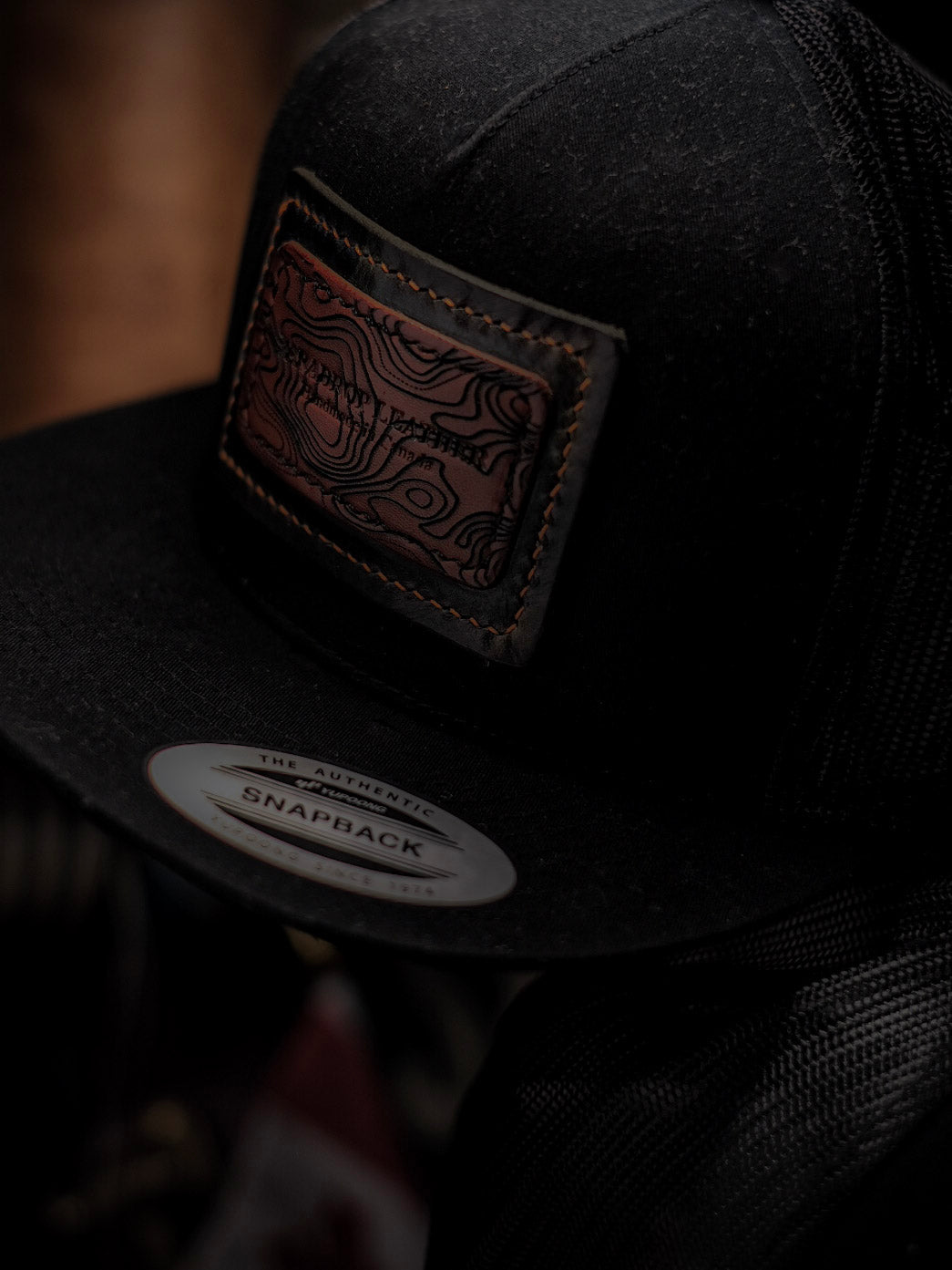 SNAP BACK CAP WITH HAND STITCHED LEATHER PATCH